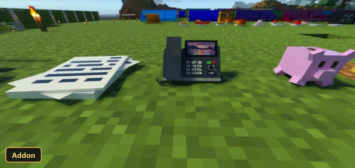 cash register, paper stack, and piggy bank on grass